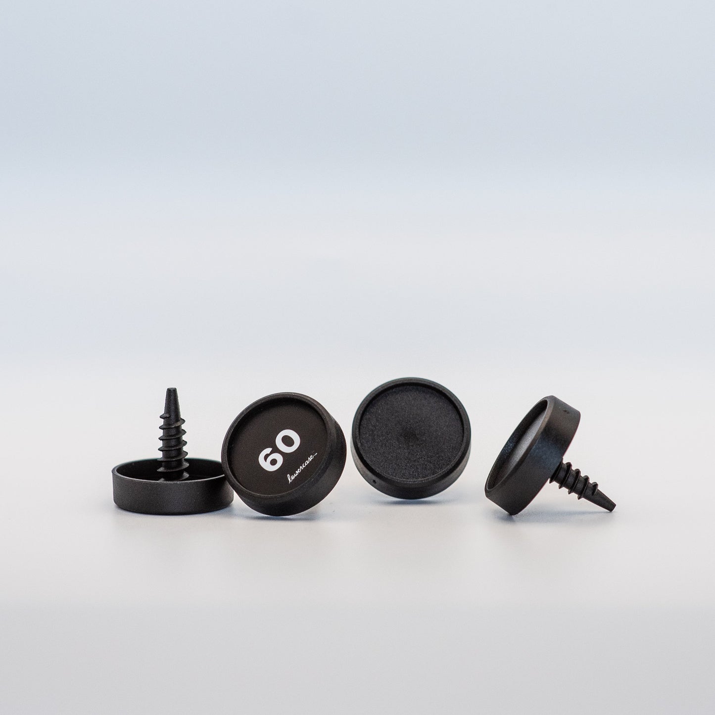 Set of black screw-on identifiers with a brand logo on a light gray background