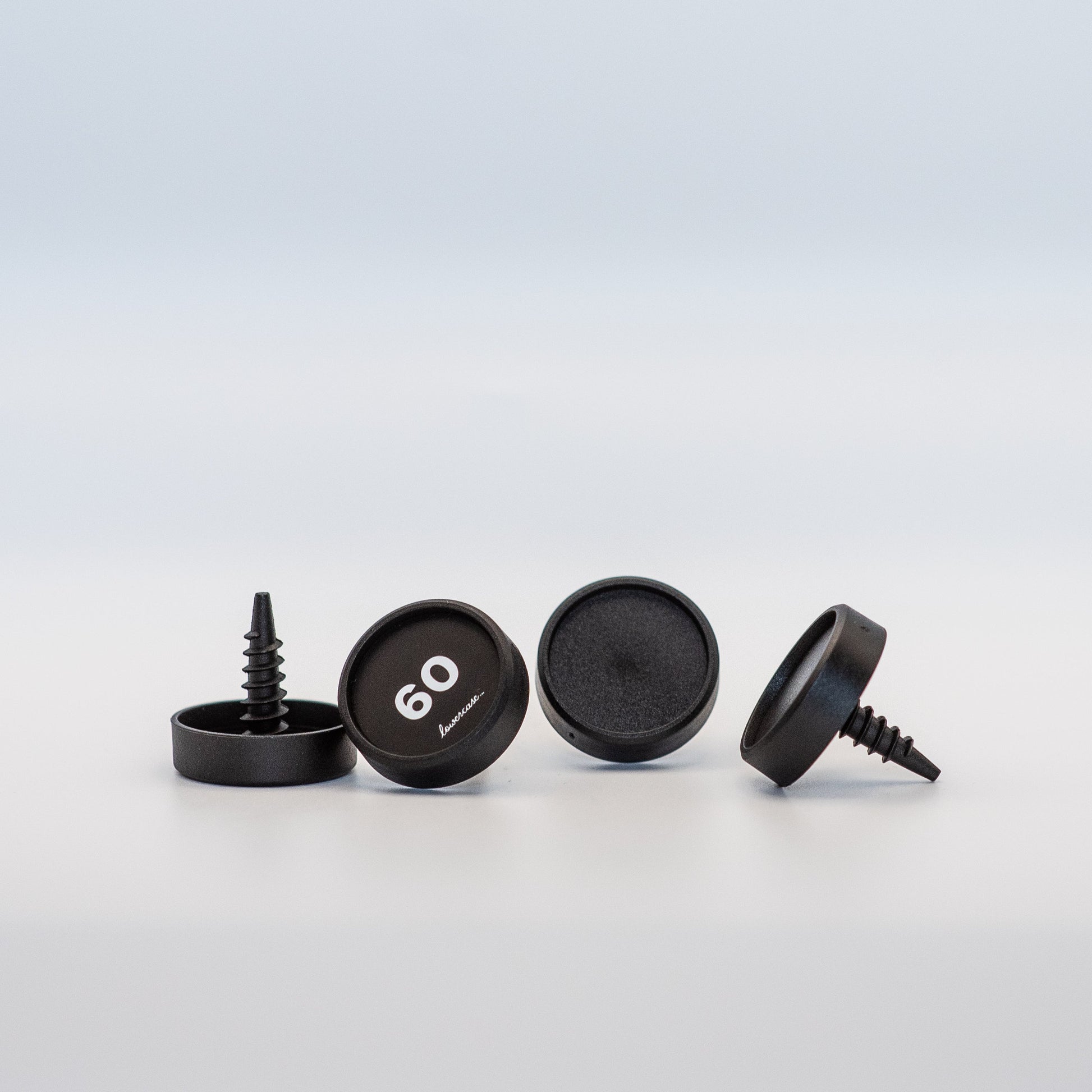 Set of black screw-on identifiers with a brand logo on a light gray background